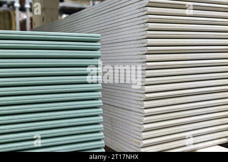 Trockenbauplatten stapeln. Gipskartonplatten werden übereinander gestapelt. Bau- und Reparaturmaterial. Stockfoto