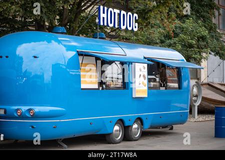 Blauer Hot Dog Van auf leerer Straße in der Stadt, mobiler Food Truck. Café im Transport, Cafeteria-Geschäft. Stockfoto