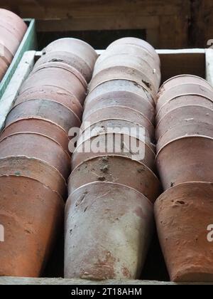 Nahaufnahme von alten rustikalen Terrakotta-Gartentöpfen, die in einer Holzkiste gestapelt sind Stockfoto