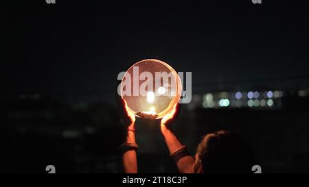 Karva Chauth ist ein eintägiges Festival, das von hinduistischen Frauen für die Sicherheit und Langlebigkeit ihrer Ehemänner gefeiert wird. Indianerin, die durch ein Sieb schaut, ce Stockfoto