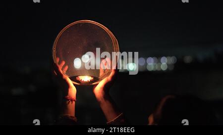 Karva Chauth ist ein eintägiges Festival, das von hinduistischen Frauen für die Sicherheit und Langlebigkeit ihrer Ehemänner gefeiert wird. Indianerin, die durch ein Sieb schaut, ce Stockfoto