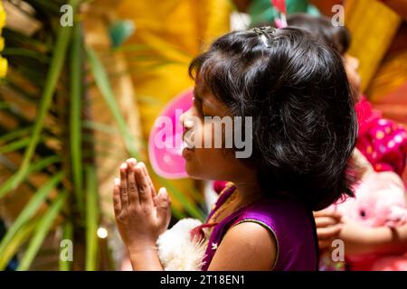 Ein junges Mädchen betet mit zusammengefalteten Händen. Stockfoto