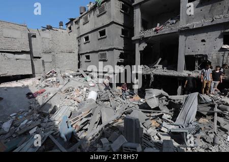 Gaza-Stadt. Oktober 2023. Menschen werden um zerstörte Gebäude und ...