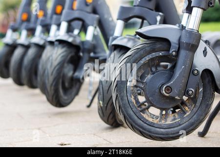 Die Räder vieler Roller stehen auf dem Bürgersteig Stockfoto