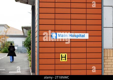 Krankenhaus NHS Personal/Krankenschwester gehen in die Arbeit hinter dem Hauptkrankenhausschild in Exeter Krankenhaus R D & E Stockfoto