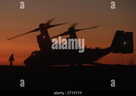 Oceanside, Usa. 26. September 2023. Ein US-Marine mit 1. Aufklärungsbataillon geht auf ein USMC MV-22 Osprey-Kipprotor-Flugzeug zu, das der mittleren Tiltrotor Squadron 164 zugewiesen ist, während es sich vorbereitet, bei Sonnenuntergang während einer gemeinsamen Aufklärungsübung mit der Royal Australian Army im Marine Corps Base Camp Pendleton abzuheben, 26. September. 2023 in Oceanside, Kalifornien. Quelle: Sgt. Amanda Taylor/USA Marine Corps/Alamy Live News Stockfoto