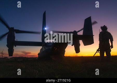 Oceanside, Usa. 26. September 2023. Ein US-Marine mit 1. Aufklärungsbataillon geht auf ein USMC MV-22 Osprey-Kipprotor-Flugzeug zu, das der mittleren Tiltrotor Squadron 164 zugewiesen ist, während es sich vorbereitet, bei Sonnenuntergang während einer gemeinsamen Aufklärungsübung mit der Royal Australian Army im Marine Corps Base Camp Pendleton abzuheben, 26. September. 2023 in Oceanside, Kalifornien. Quelle: Sgt. Amanda Taylor/USA Marine Corps/Alamy Live News Stockfoto