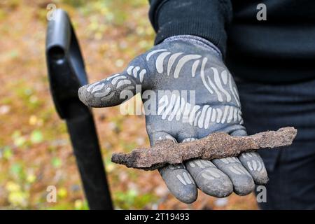 Lychen, Deutschland. Oktober 2023. Munitionsminer Steffan zeigt ein Stück Munition, das hier auf dem ehemaligen Militärübungsgelände in Tangersdorf gefunden wurde. Ein Teil der Heidefläche der Heinz Sielmann Stiftung steht noch aus. Die Stiftung schafft derzeit die Voraussetzungen dafür, dass die Heide in den kommenden Jahren auf dem ehemaligen Militärübungsgelände wieder blühen kann und das für die Artenvielfalt wertvolle Freiland nicht nach und nach zu Wald wird. Quelle: Jens Kalaene/dpa/Alamy Live News Stockfoto