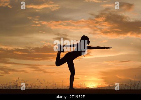 Silhouette einer Frau, die Yoga bei Sonnenuntergang macht, Thailand Stockfoto