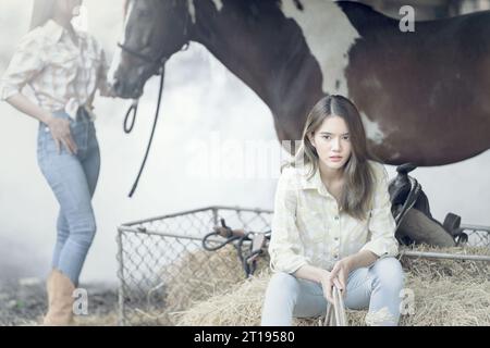 Zwei Frauen und ein Pferd in einem Stall, Thailand Stockfoto