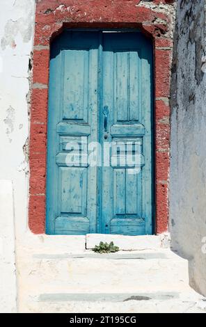 Zwei blaue Holztüren bilden den Eingang zu einer Privatwohnung in Griechenland. Stockfoto