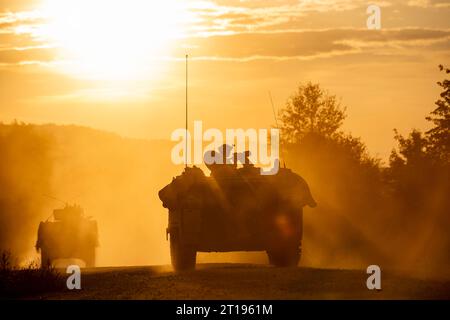 Hohenfels, Deutschland . 13. September 2023. Ein Konvoi von Soldaten der US-Armee mit dem 1. Bataillon des 4. Infanterieregiments rollt bei Sonnenuntergang durch ein Trainingsdorf mit gepanzerten Fahrzeugen während der Saber Junction 23 im Joint Multinational Readiness Center am 13. September 2023 bei Hohenfels. Quelle: SFC Michel Sauret/U.S. Army/Alamy Live News Stockfoto