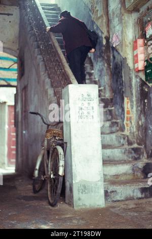 Ältere Dame, die in Peking China geheimnisvolle alte Stufen hinaufgeht - gescannt 35 mm negativ - Teil des zunehmenden Sets - aufgenommen während der Frühjahrszeit 2011 Stockfoto