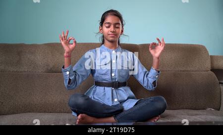 Porträt eines wunderschönen Kindes, das im Freien Yoga übt. Schöne Kinder üben Yoga Asana oder machen Gymnastik Übungen. Kleine Kinder, die in Lotus po meditieren Stockfoto