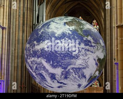 Truro, Großbritannien. Oktober 2023. Gaia ist ein Kunstwerk des britischen Künstlers Luke Jerram. Mit einem Durchmesser von sieben Metern bietet Gaia detaillierte NASA-Bilder der Erdoberfläche mit 120 dpi. Das Kunstwerk bietet die Möglichkeit, unseren Planeten in dieser Größenordnung zu sehen, der in drei Dimensionen in der wunderschönen Architektur der Kathedrale von Truro schwingt. Quelle: Keith Larby/Alamy Live News Stockfoto