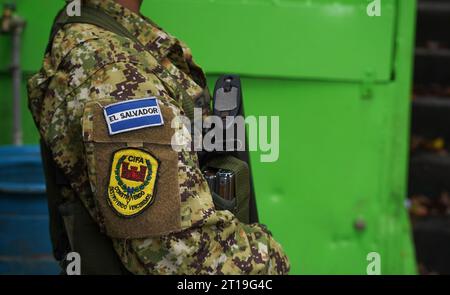 El Salvador, El Salvador. Oktober 2023. Ein bewaffneter Soldat steht auf der Wache und führt auf seinem Arm das Motto: "Mit Bau und Zerstörung werden wir gewinnen." Im umstrittenen Kampf gegen die Kriminalität durch den konservativen Präsidenten Bukele spielt das Militär eine wichtige Rolle im zentralamerikanischen Land. Seit anderthalb Jahren gibt es dort einen Ausnahmezustand mit Einschränkungen der Grundrechte. Quelle: Camilo Freedman/dpa/Alamy Live News Stockfoto