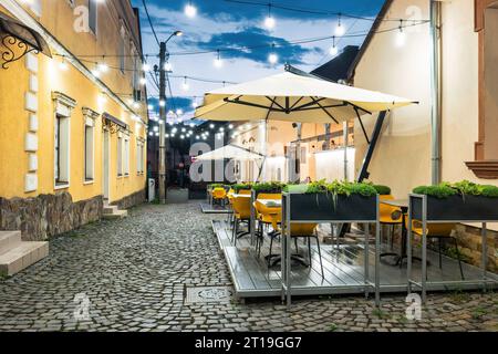 Restaurant Terrasse in der Innenstadt von Targu Mures, Transsilvanien, Rumänien bei Nacht. Stockfoto