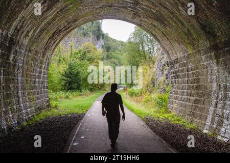 Man läuft auf dem Monsal Trail durch einen stillgelegten Eisenbahntunnel bei Chee Dale im Derbyshire English Peak District Stockfoto