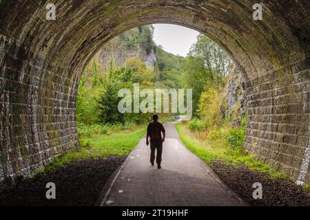 Man läuft auf dem Monsal Trail durch einen stillgelegten Eisenbahntunnel bei Chee Dale im Derbyshire English Peak District Stockfoto