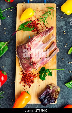 Leckere rohe Lammrippchen und Gewürze auf dem Küchentisch. Stockfoto