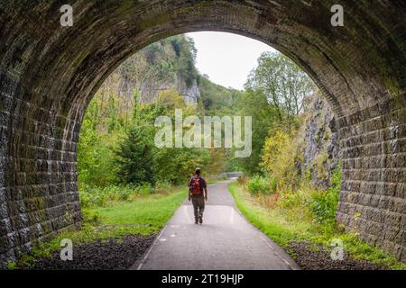 Man läuft auf dem Monsal Trail durch einen stillgelegten Eisenbahntunnel bei Chee Dale im Derbyshire English Peak District Stockfoto