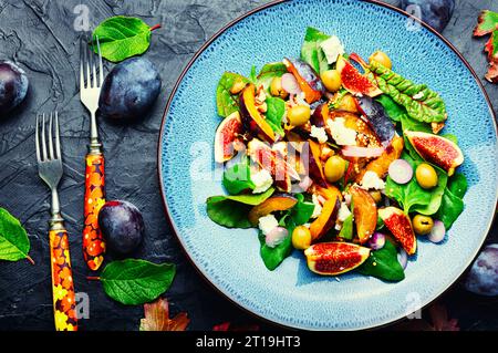 Ungewöhnlicher Salat mit Feigen, Pflaumen, Kräutern und Oliven. Stockfoto