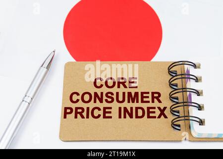 Wirtschafts- und Finanzkonzept. Auf der Flagge Japans befinden sich ein Stift und ein Notizbuch mit der Aufschrift „Core Consumer Price Index“. Stockfoto