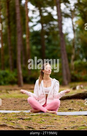 Wunderschönes Mädchen, das im Freien Yoga praktiziert Stockfoto