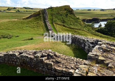 Die Hadrianische Mauer geht auf das römische Reich in der Nähe des Steinbruchs Cawfields in Schottland zurück. Der Steinbruch, aus dem die Steine dieses Sektors stammen, ist rückwärts. Stockfoto