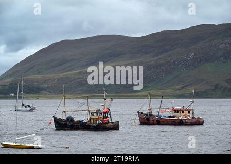Zwei kleine Fischerboote ankerten vor dem Hafen von Ullapoll in Schottland. Stockfoto