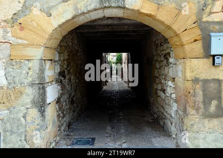 Eine Gasse in die Mauern der bastide-Stadt Monpazier in der französischen Dordogne. Die Stadt ist ein beliebtes Touristenziel. Stockfoto