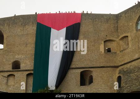 Auf Initiative der Aktivisten des Netzwerks für Palästina wurde eine 30 Meter lange große Flagge mit den Farben Palästinas für einige Minuten auf den Festungsmauern von Castel Sant'Elmo, der alten Festung auf dem Vomero-Hügel in Neapel, ausgestellt. Etwa vierzig Aktivisten waren anwesend, die kurz darauf aufbrachen und anti-israelische Gesänge sangen. Die Flagge wurde einige Minuten lang angebracht und dann entfernt, was die Aufmerksamkeit der anwesenden Touristen auf sich zog. Die Initiative findet am Vorabend der propalästinensischen Prozession statt, die morgen Nachmittag in Neapel von der Piazza Garibaldi aus beginnen soll. Stockfoto