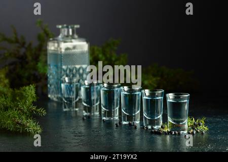 Blaue Gin- und wacholderzweige auf einem Vintage dunkelblauen Tisch. Gin mit wacholderbeeren. Kopierbereich. Stockfoto