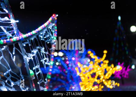 Nahaufnahme einer glühenden Beleuchtung auf der Straße im Winter, verschwommen. Schöner Winter heller Hintergrund mit festlichen Straßenlaternen Stockfoto