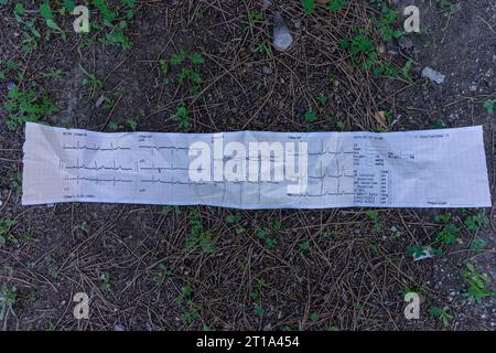Verlassene EKG-Tracing am Boden, ein ergreifendes Symbol vergessener medizinischer Geschichte. Stockfoto