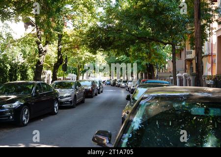 Viele Autos parkten hintereinander auf beiden Seiten einer Straße entlang von Häusern in Bukarest Stockfoto