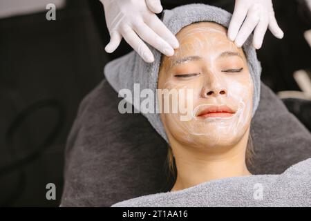 Frau Gesichtsmassage Gesichtshaut-Behandlung mit natürlicher Essence Kräuterextrakt Feuchtigkeitscreme in der Schönheits-Spa-Klinik. Stockfoto