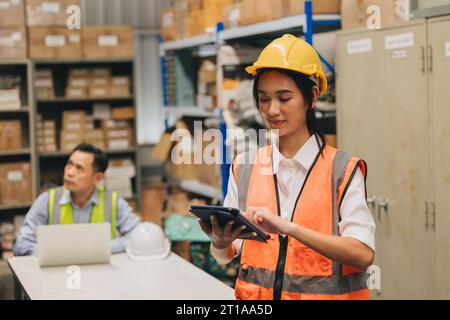 Ingenieurin arbeitet in einem Lager für Hardware-Produkte mit einer Software zur Verwaltung des Lagerbestands für Tablet-Teile Stockfoto