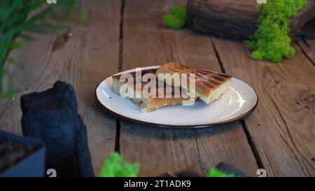Weiche belgische Waffeln mit Schokoladenbelag beträufeln, während Dessert zubereitet wird. Machen Sie Süßigkeiten aus weichen Waffeln und süßem Eis Stockfoto