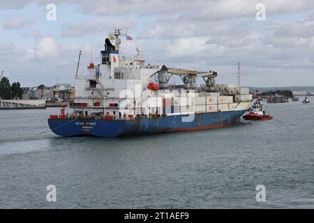 Ein Schlepper bereitet sich darauf vor, das Kühlfrachtschiff MV STAR ZUERST im internationalen Hafen zu bringen Stockfoto