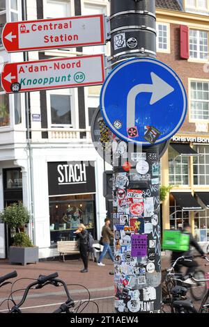 Blaues Straßenschild in Amsterdam, Niederlande, mit vielen Aufklebern Stockfoto