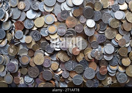 Ein Haufen verschiedener Geldmünzen unterschiedlicher Stückelungen aus verschiedenen Ländern. Devisenwechsel- und Finanzierungskonzept. Viele verschiedene Münzen. Stockfoto