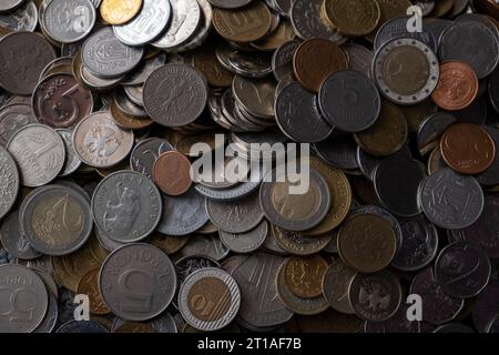 Ein Haufen verschiedener Geldmünzen unterschiedlicher Stückelungen aus verschiedenen Ländern. Devisenwechsel- und Finanzierungskonzept. Viele verschiedene Münzen. Stockfoto