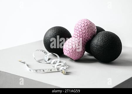 Rosafarbene Erdnusswalze aus Gummischaum, schwarzer Massageball. Yoga, Fitnessgeräte. Zentimeterband zur Messung des Taillenvolumens. Stretching, Pilates Accessori Stockfoto