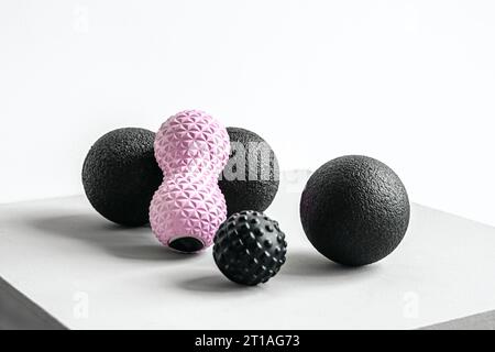 Rosafarbene Erdnusswalze aus Gummischaum, schwarzer Massageball. Yoga, Fitnessgeräte. Zentimeterband zur Messung des Taillenvolumens. Stretching, Pilates Accessori Stockfoto