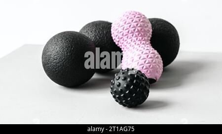 Rosafarbene Erdnusswalze aus Gummischaum, schwarzer Massageball. Yoga, Fitnessgeräte. Zentimeterband zur Messung des Taillenvolumens. Stretching, Pilates Accessori Stockfoto