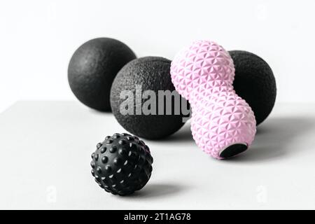 Rosafarbene Erdnusswalze aus Gummischaum, schwarzer Massageball. Yoga, Fitnessgeräte. Zentimeterband zur Messung des Taillenvolumens. Stretching, Pilates Accessori Stockfoto