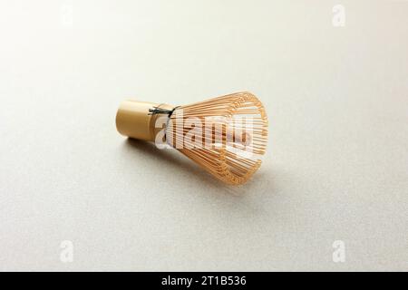 Bambus Matcha Teebesen oder Chasen. Isoliert auf cremestrukturiertem Tischhintergrund. Chasen für Japan Green Match Tea Stockfoto