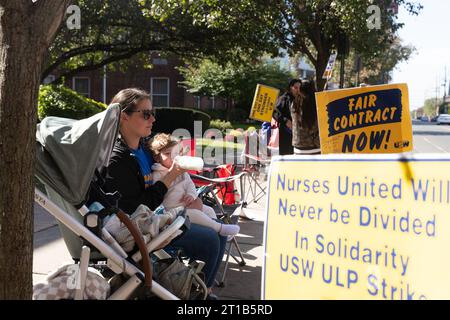 New Brunswick, New Jersey, USA. Oktober 2023. CARLEY VITALE, OP-Krankenschwester pflegt ihre Tochter während des Streiks vor dem Robert Wood Johnson Hospital. Die Krankenschwestern streiken für eine sichere Personalbesetzung und warten auf die Ergebnisse der aktuellen Verhandlungen, die Beamte sagten. (Kreditbild: © Brian Branch Price/ZUMA Press Wire) NUR REDAKTIONELLE VERWENDUNG! Nicht für kommerzielle ZWECKE! Stockfoto