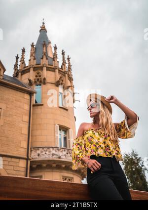 Blonde Frau in einem gelben Vintage-Outfit mit Hut Stockfoto